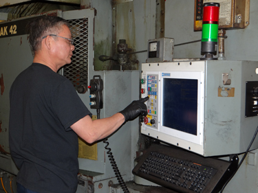 operator using Centroid M400 CNC control on a Blanchard CNC grinder